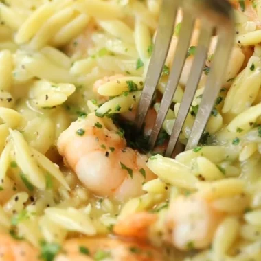 Garlic Butter Prawn Orzo dish served in a bowl, garnished with herbs.