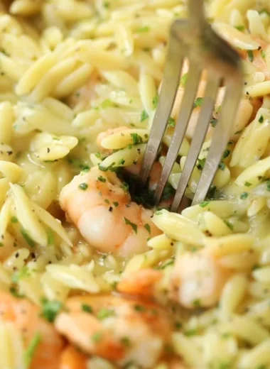 Garlic Butter Prawn Orzo dish served in a bowl, garnished with herbs.