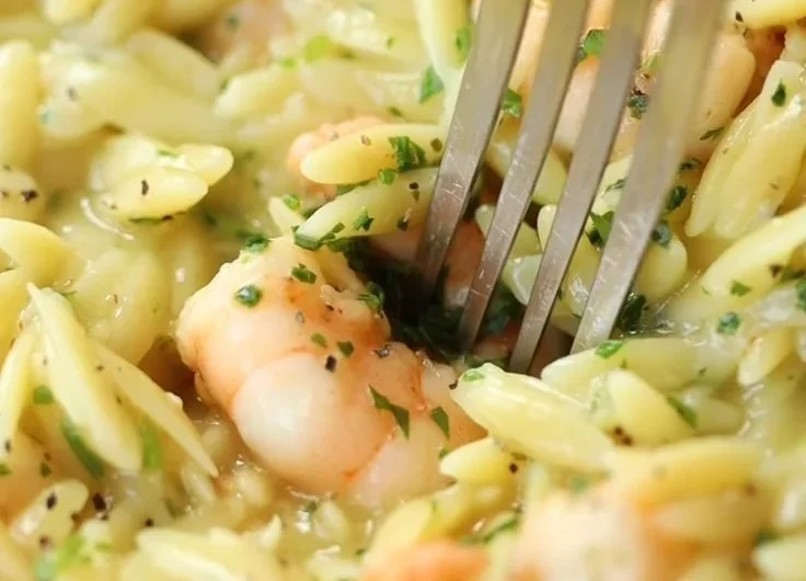 Garlic Butter Prawn Orzo dish served in a bowl, garnished with herbs.
