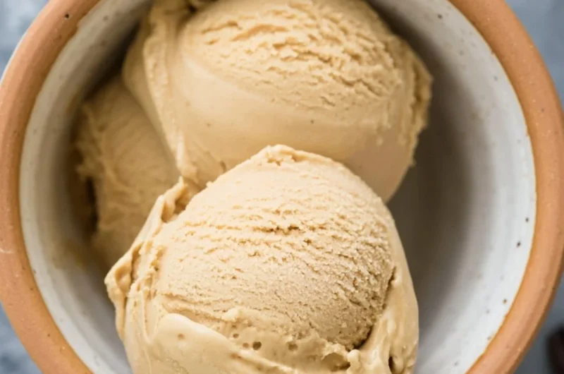 Delicious coffee ice cream served in a cup with coffee beans around it.