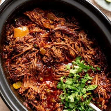 Delicious cozy beef barbacoa served with fresh toppings in a warm dish