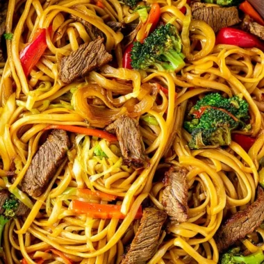 Cozy beef stir fry with linguini served in a bowl, garnished with vegetables.