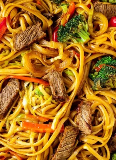 Cozy beef stir fry with linguini served in a bowl, garnished with vegetables.