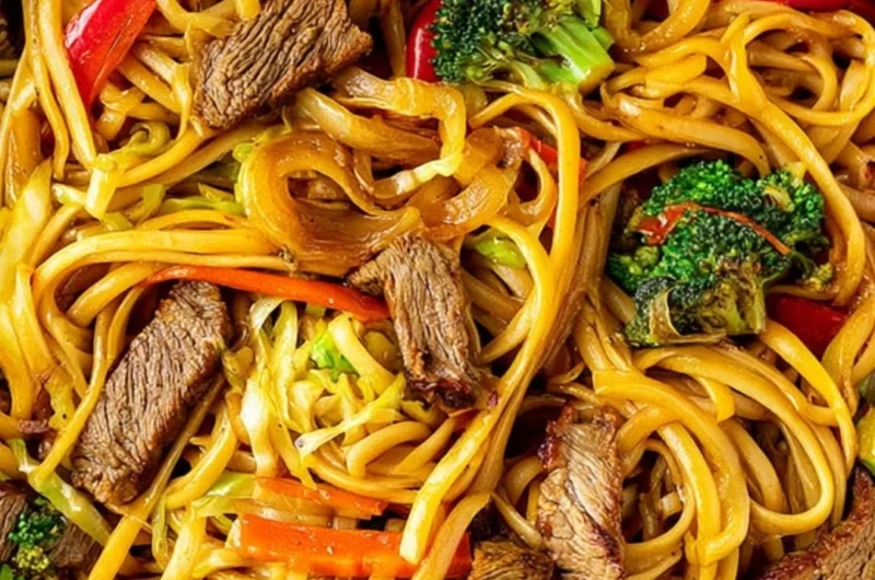 Cozy beef stir fry with linguini served in a bowl, garnished with vegetables.