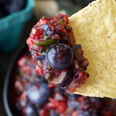 Bowl of fresh blueberry salsa with chopped vegetables and herbs