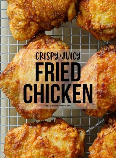 Deliciously crispy fried chicken thighs on a plate, garnished with herbs.