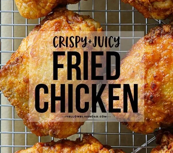 Deliciously crispy fried chicken thighs on a plate, garnished with herbs.