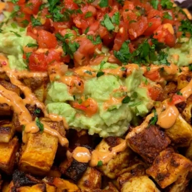 A colorful high protein power bowl filled with quinoa, vegetables, and toppings.