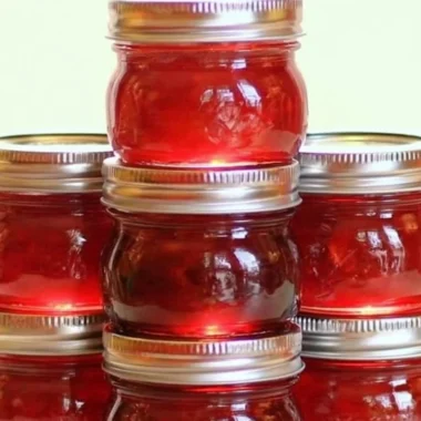 Homemade rhubarb cinnamon jam in a jar with rustic background
