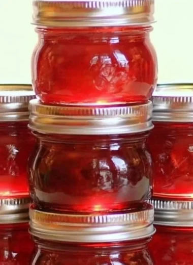 Homemade rhubarb cinnamon jam in a jar with rustic background