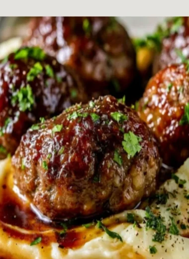 Salisbury steak meatballs served with garlic herb mashed potatoes on a plate