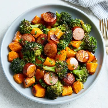 Sheet pan featuring roasted sausage and sweet potatoes, a flavorful one-pan meal.