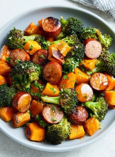 Sheet pan featuring roasted sausage and sweet potatoes, a flavorful one-pan meal.