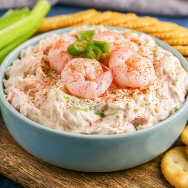 Creamy shrimp dip served in a bowl with crackers and vegetables