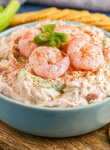 Creamy shrimp dip served in a bowl with crackers and vegetables