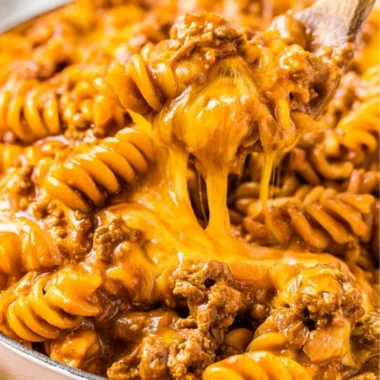 Creamy enchilada pasta with savory sauce and toppings, perfect for family dinners.
