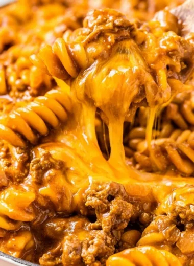 Creamy enchilada pasta with savory sauce and toppings, perfect for family dinners.