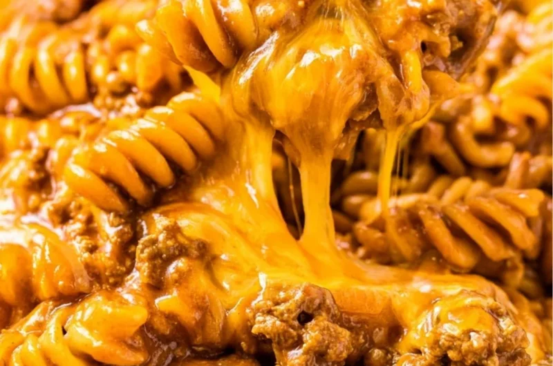 Creamy enchilada pasta with savory sauce and toppings, perfect for family dinners.