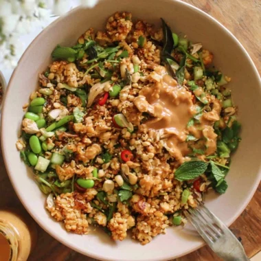 A colorful satay crispy rice salad with vibrant vegetables and crunchy peanuts.