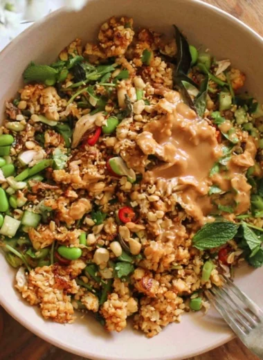 A colorful satay crispy rice salad with vibrant vegetables and crunchy peanuts.