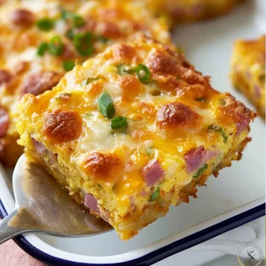 Savory breakfast casserole with hash browns, eggs, ham, and cheese baked to perfection.