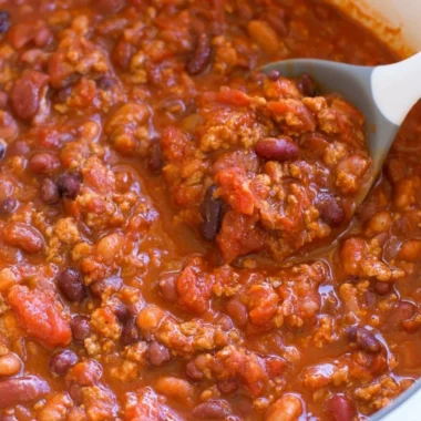 Bowl of healthy turkey chili garnished with fresh herbs and served with bread.