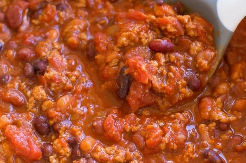 Bowl of healthy turkey chili garnished with fresh herbs and served with bread.