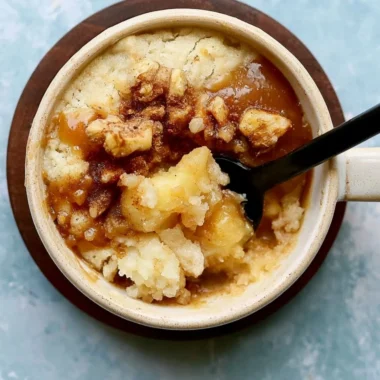 Cozy apple mug cake topped with cinnamon in a white mug