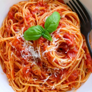 Cozy pasta tomato dish with vibrant red sauce and fresh herbs