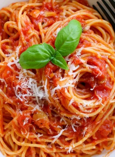 Cozy pasta tomato dish with vibrant red sauce and fresh herbs