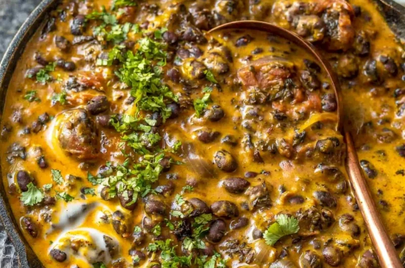 Creamy black bean curry served in a bowl with fresh herbs