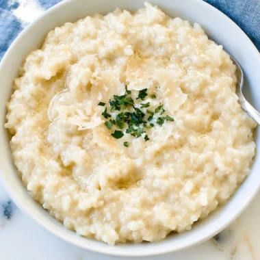 Bowl of creamy Parmesan risotto garnished with fresh herbs