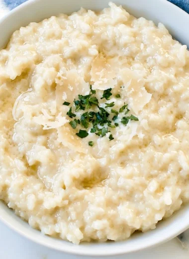 Bowl of creamy Parmesan risotto garnished with fresh herbs