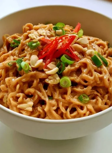 Creamy peanut butter ramen bowl topped with vegetables and herbs