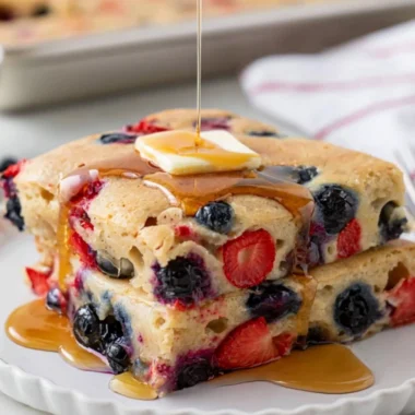 Delicious gluten free sheet pan pancake served with fresh berries and syrup