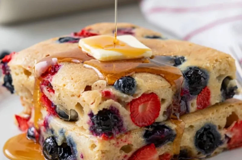 Delicious gluten free sheet pan pancake served with fresh berries and syrup