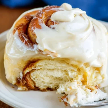 Freshly baked sourdough cinnamon rolls topped with icing for a cozy breakfast treat.
