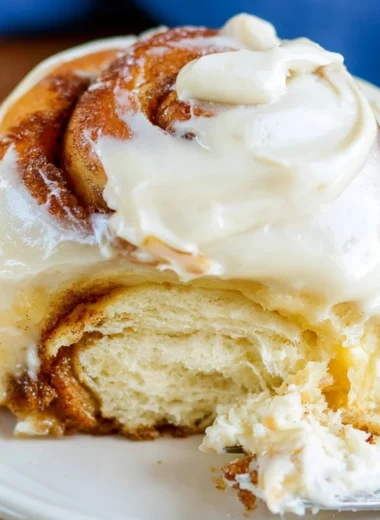 Freshly baked sourdough cinnamon rolls topped with icing for a cozy breakfast treat.