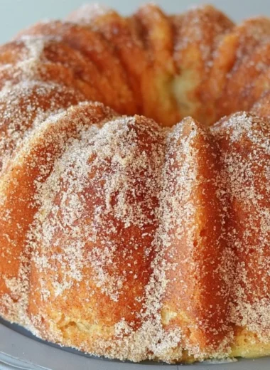 Delicious Apple Cider Bundt Cake topped with caramel apple glaze on a serving plate.
