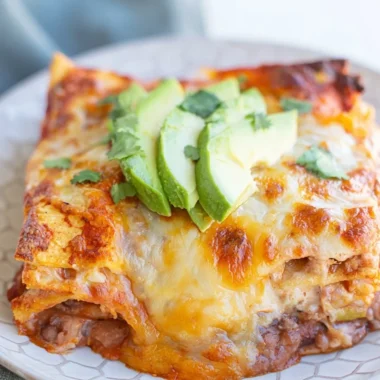 Cozy bean and cheese enchilada casserole topped with melted cheese