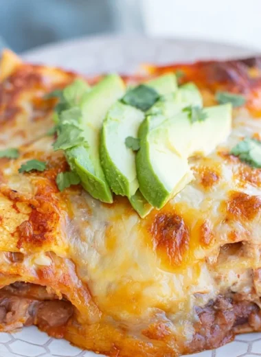Cozy bean and cheese enchilada casserole topped with melted cheese