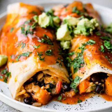 Delicious cozy vegetarian enchiladas served on a plate, garnished with fresh herbs.