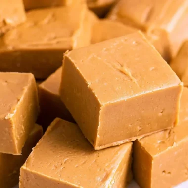 Delicious creamy peanut butter fudge squares on a wooden plate