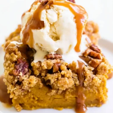 Slice of Pumpkin Pie Crunch Cake topped with whipped cream and spices