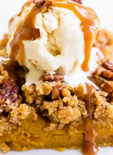 Slice of Pumpkin Pie Crunch Cake topped with whipped cream and spices