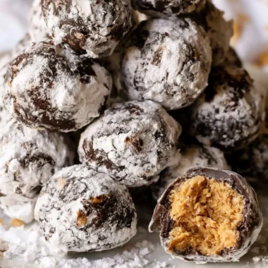 Puppy Chow truffles drizzled with chocolate and sprinkled with powdered sugar