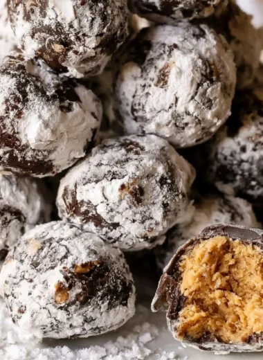 Puppy Chow truffles drizzled with chocolate and sprinkled with powdered sugar