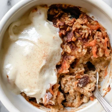 Delicious carrot cake baked oatmeal served in a bowl with frosting