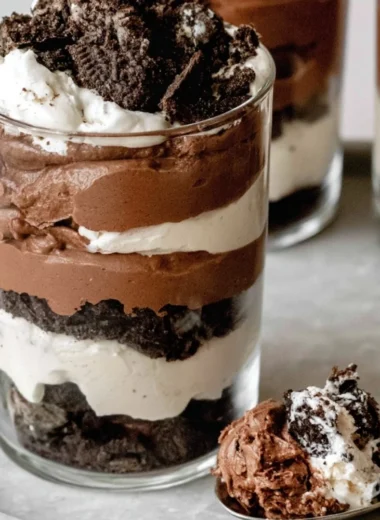 Delicious chocolate parfait dessert featuring layers of cream and chocolate.