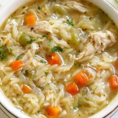 Bowl of Lemon Chicken Orzo Soup filled with chicken, orzo, and fresh lemon slices